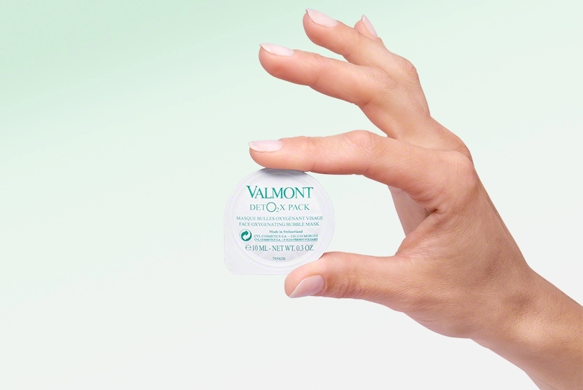 Valmont Deto2x Pack Product 1 pod held in a hand with a green and white gradient background