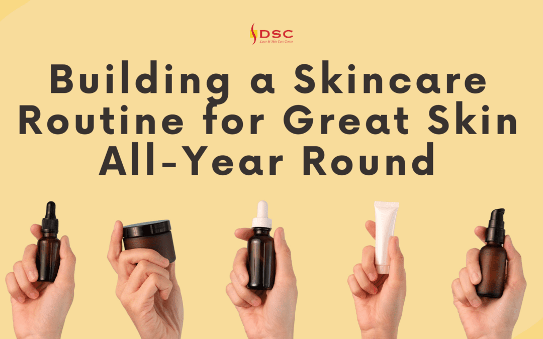 dsc building a skincare routine for great skin all-year round blog banner with the text building a skincare routine for great skin all-year round above five hands holding skincare product bottles on a yellow background with DSC logo at the top center