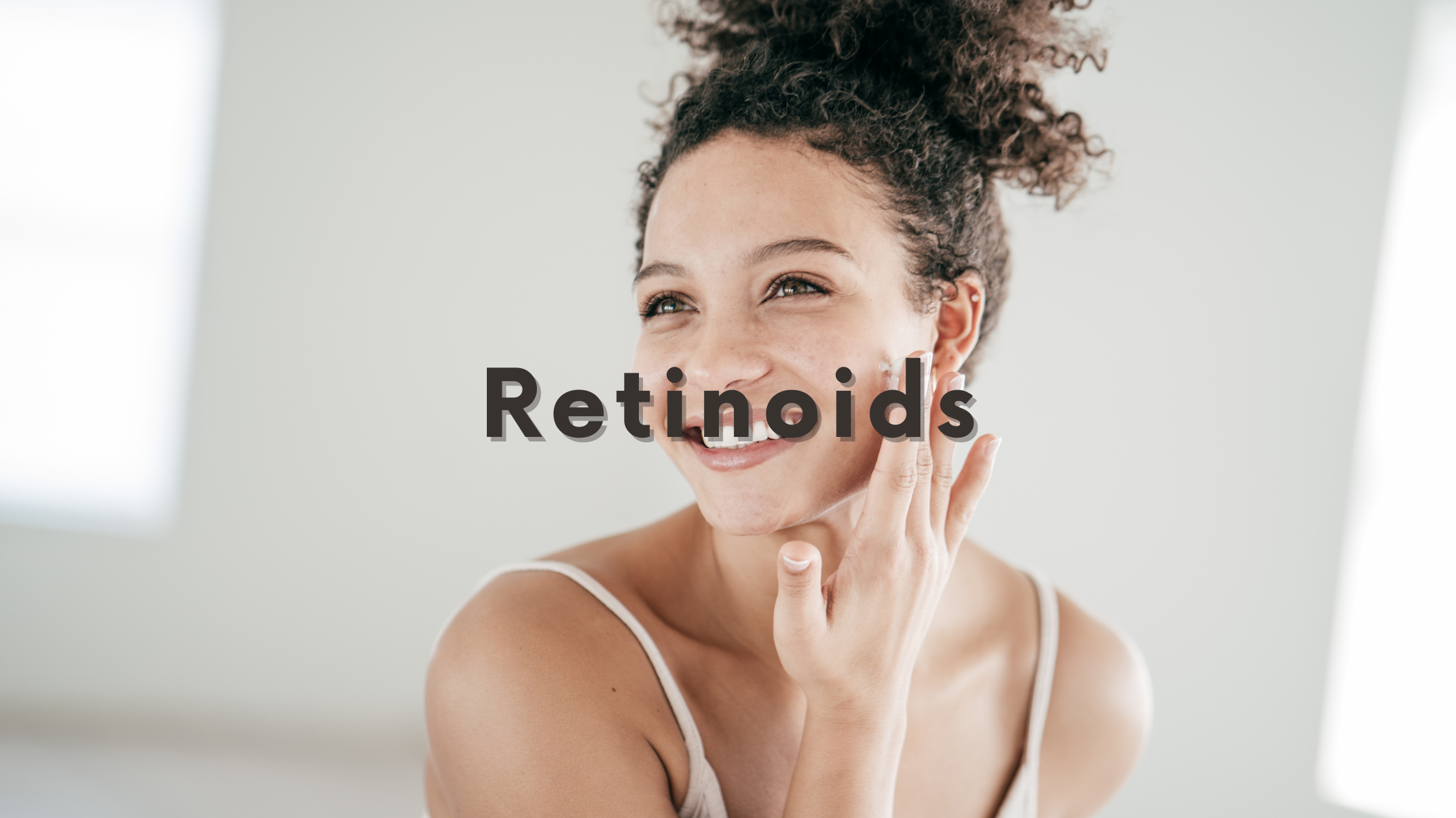 DSC Retinoids Blog Graphic with image of smiling woman touching face with text "retinoids" centered